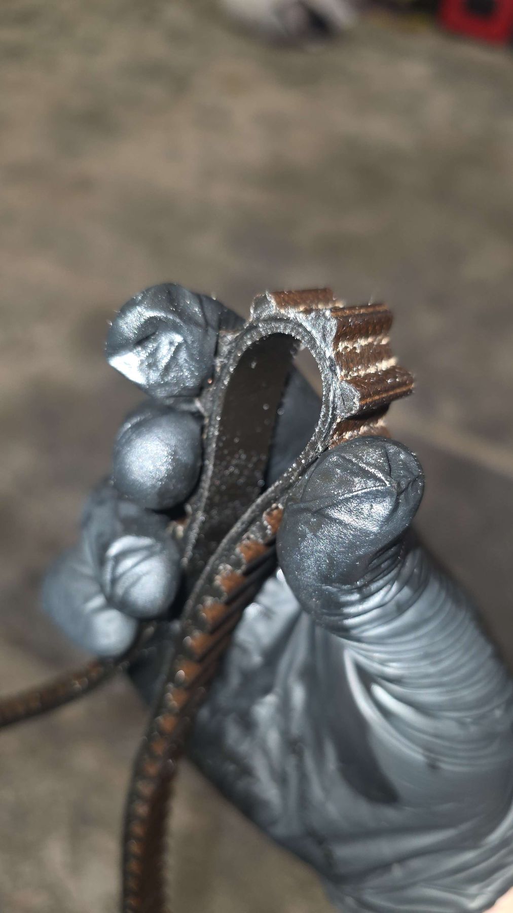 A failed wet belt with stripped and worn teeth